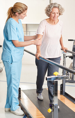 Proceso de fisioterapia ayudando a paciente.